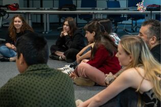 Warsztaty teatralne w Centrum Wielokulturowym - grupa siedzi na dywanie